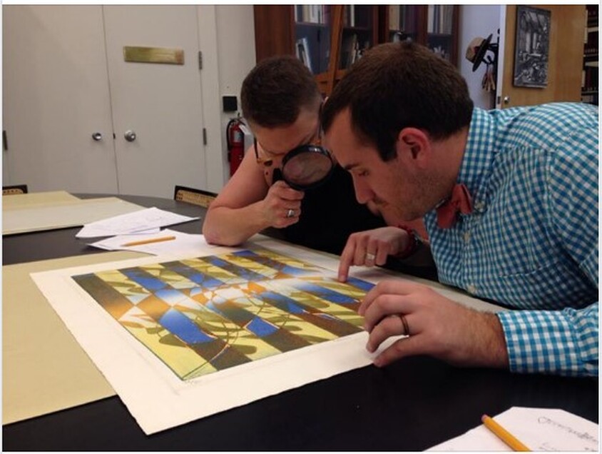 Picture of Ben Levy and Tru Ludwig looking at Hayter's print, Pillars, 1974.