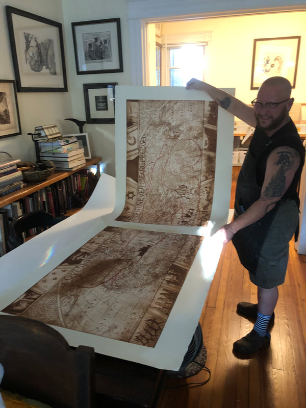 picture of artist holding freshly printed etching